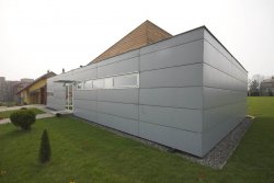 Pro konstrukci zavěšené fasády byly použity cementotřískové desky opatřené šedým nátěrem, který kontrastuje s přírodním modřínovým dřevem