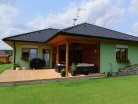 moderni-drevostavba-bungalov-haas-fertigbau-exterier-zelena-fasada-drevena-terasa-zahrada