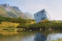 Osobitý návrh horské chaty ve tvaru kostky připomíná v krajině bludný balvan