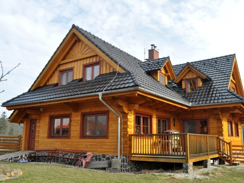 Dokončená stavba roubenky s typickou střechou s polomalbami.