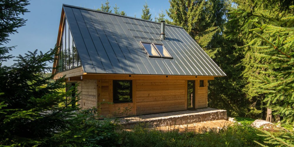Zpustošenou chatu na kraji lesa nahradili moderní víkendovou dřevostavbou