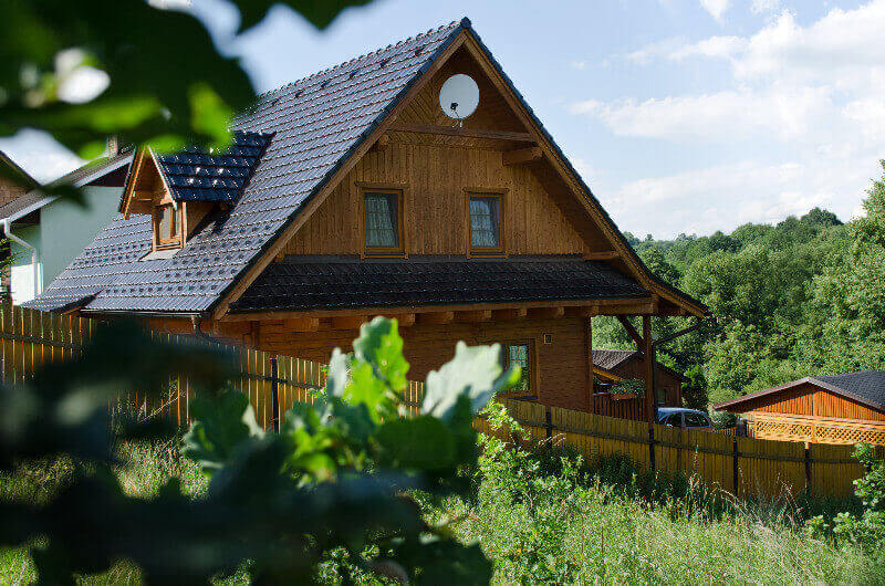 Srubový dům z hraněných trámů si manželé postavili na klidném místě u lesa